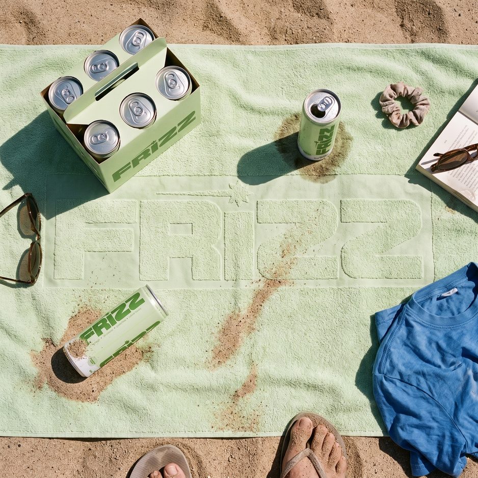 THE TOWEL, ON SAND: the Frizz towel and the six-pack carrier at noon