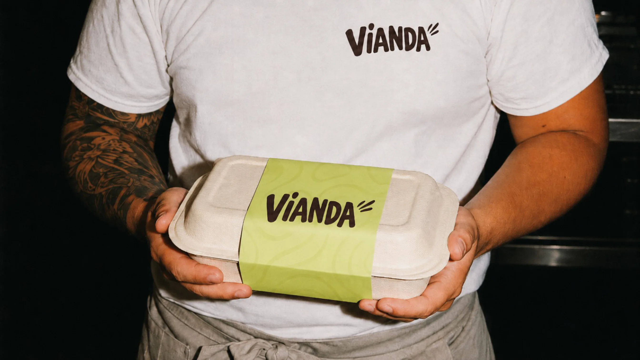 The branded Vianda tupper, held in a hand